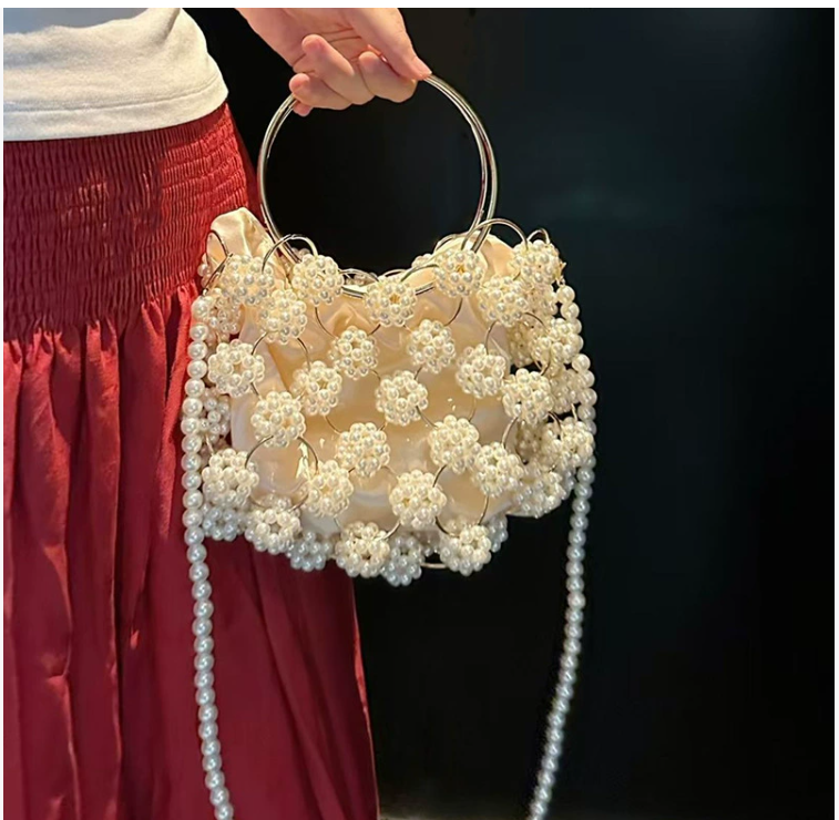 Hollowed-out iron ring handle with pearl ball and inner pocket, hand-woven crossbody bag, fresh and elegant women's style.