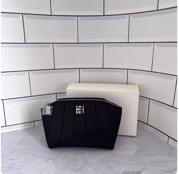 This is a complimentary cool black cosmetic bag from the boutique, featuring a simple and stylish shell design. It's a convenient clutch/toiletry bag.